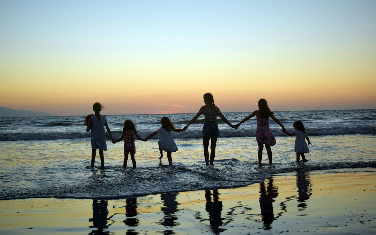 Família na praia ao pôr do sol